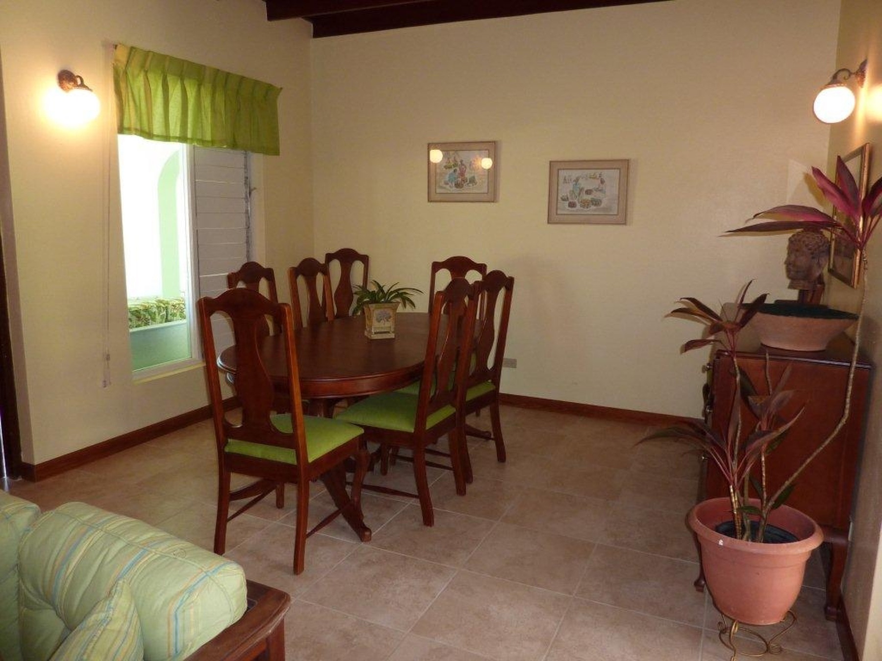The dining room with a wooden table and chairs and a window to the garden