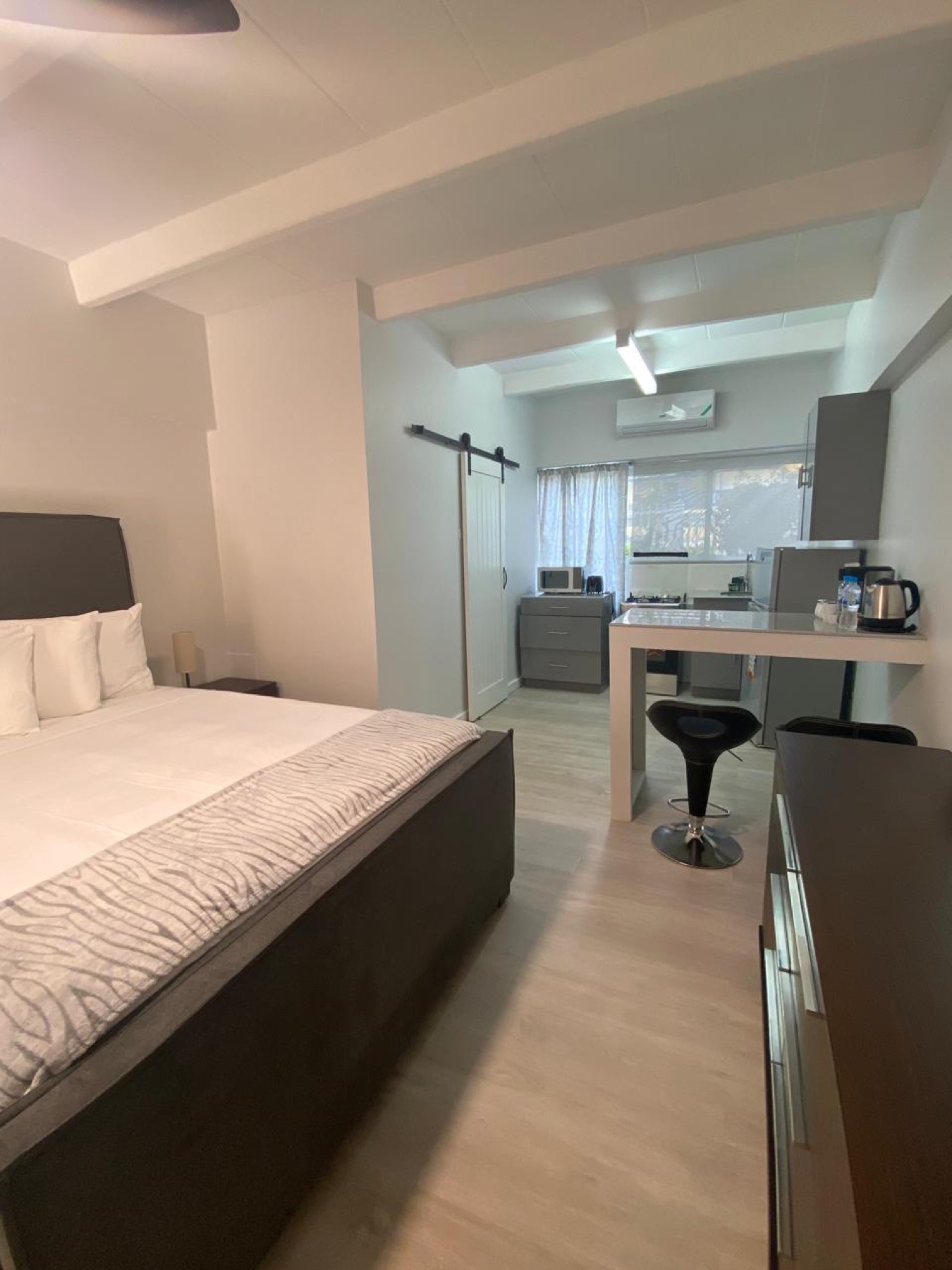 A bright studio suite with a bed, a kitchenette and a small dining counter