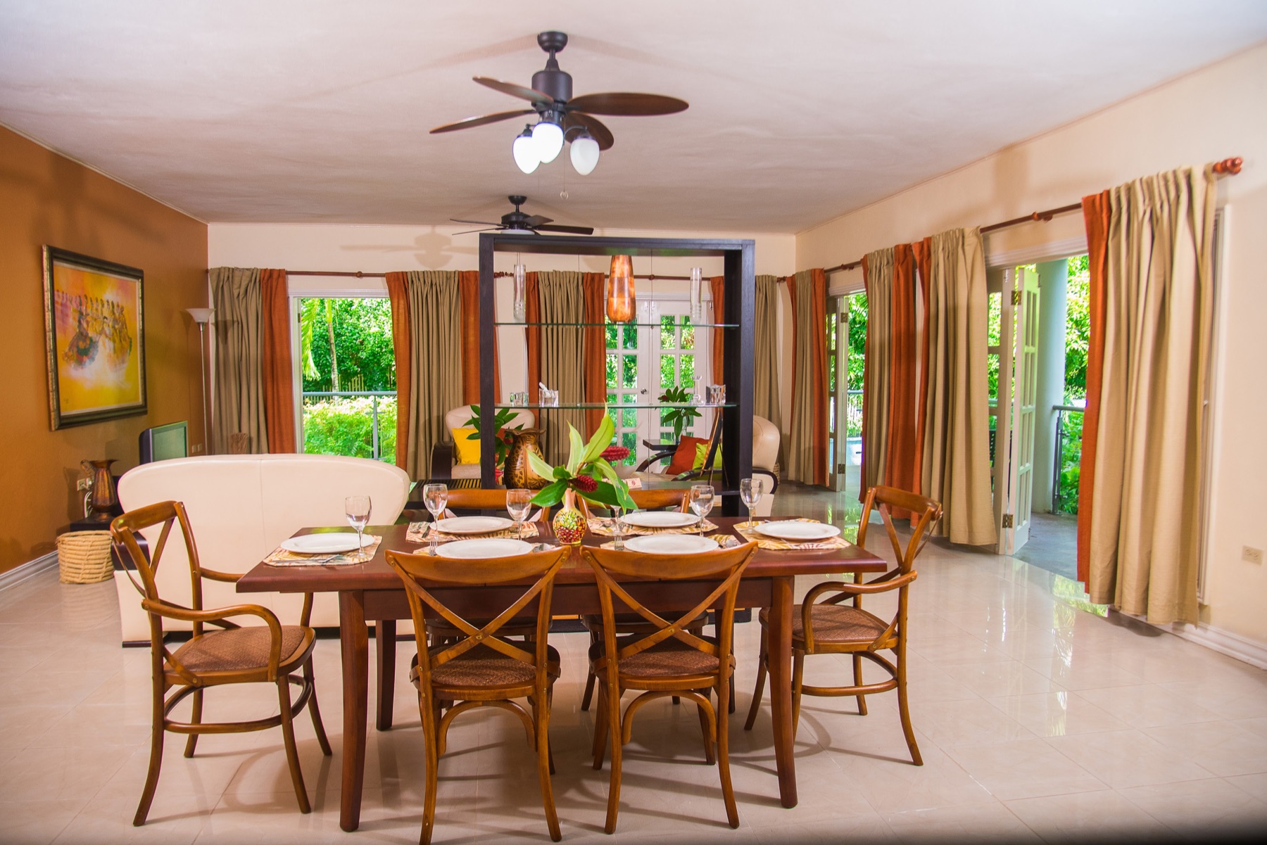 The dining table set for a meal, open to the kitchen and the garden doors
